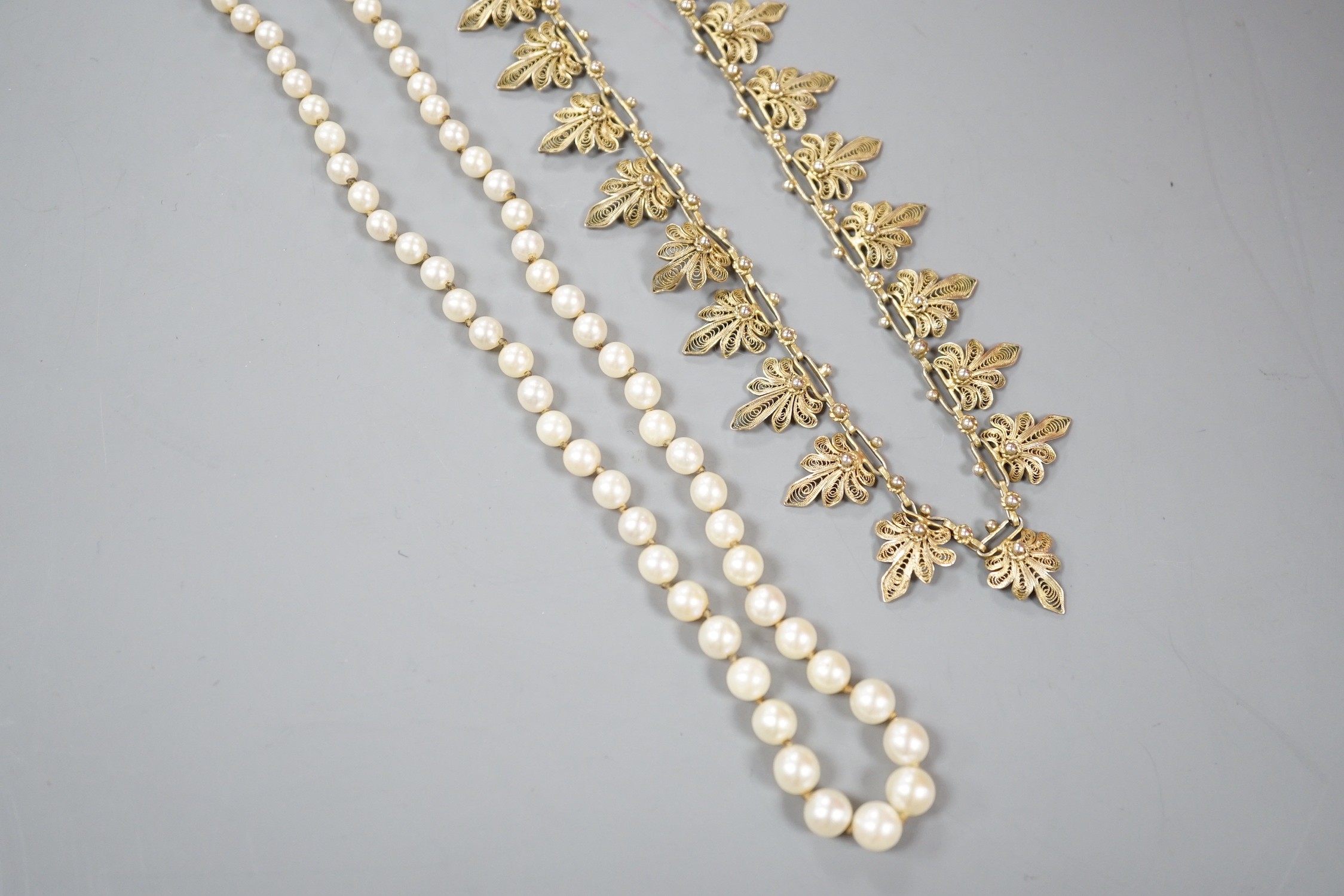 A single strand graduated cultured pearl necklace, with 925 clasp, 21cm and a gilt white metal filigree necklace.